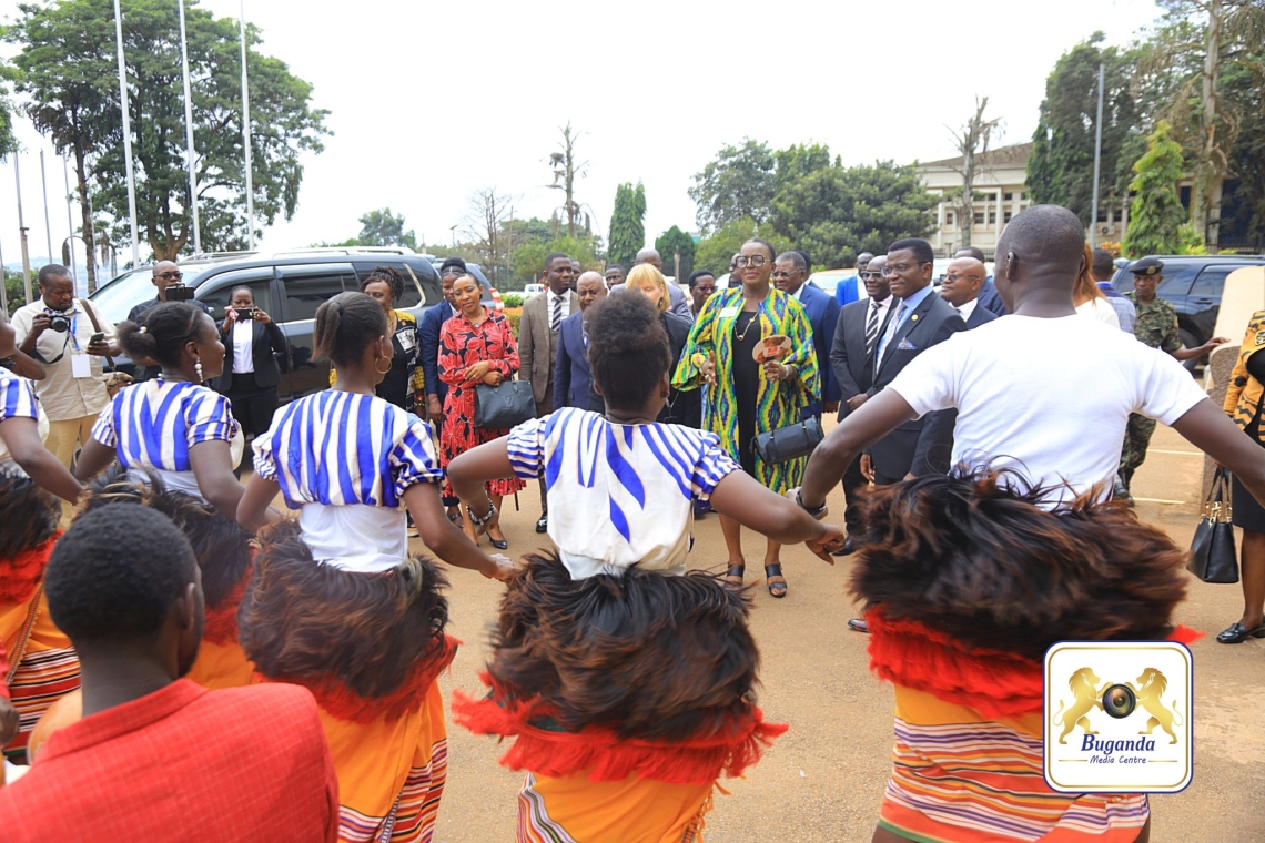 Traditional dancers welcome Stephanie Urchick as Katikkiro Mayiga observes her arrival at Bulange